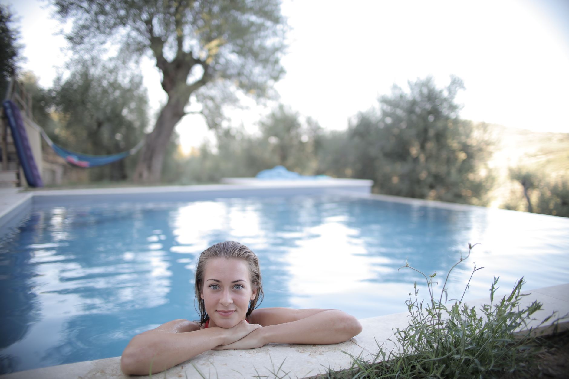 A woman enjoying relaxation in a swimming pool surrounded by nature.