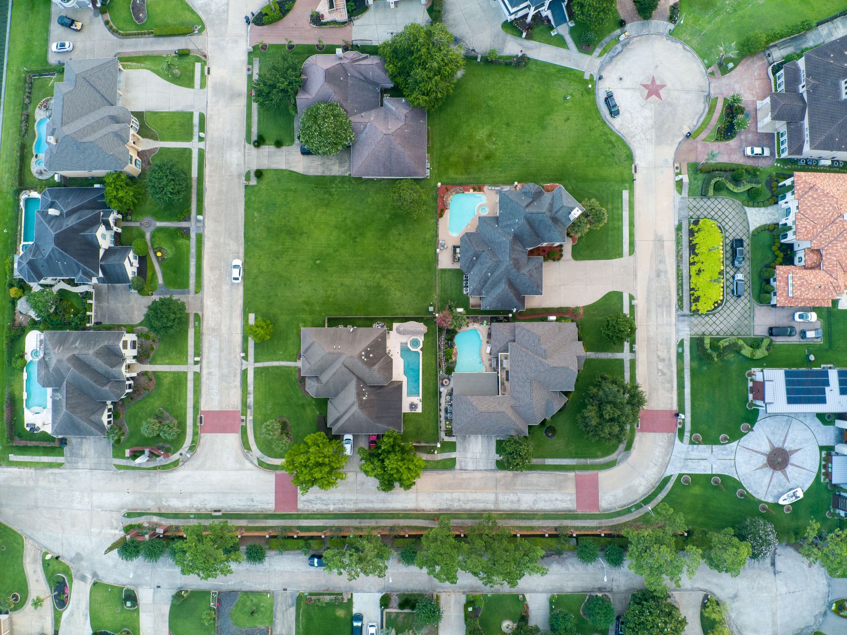Drone shot of suburban houses with pools in Houston, TX, from above.